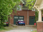 A picture of a house with a car parked in front of its garage